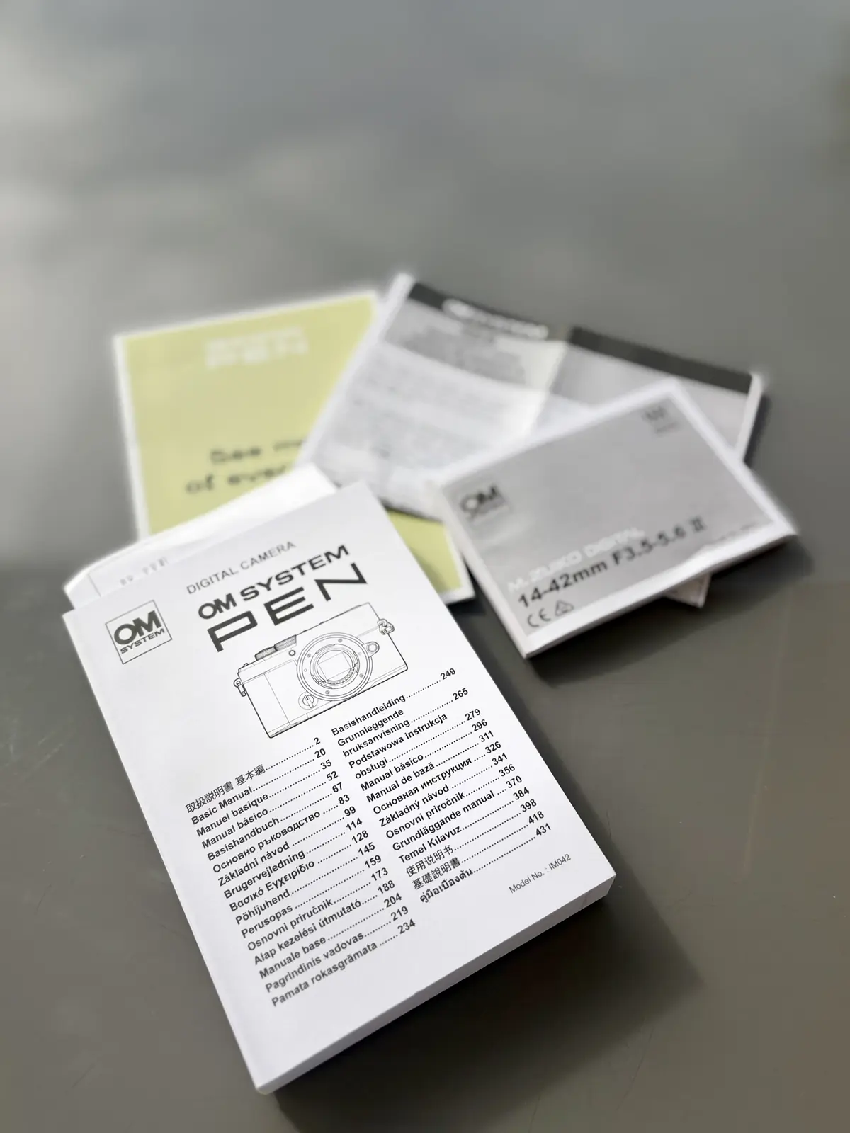 Livret multilingue de l’OM SYSTEM PEN et documents fournis